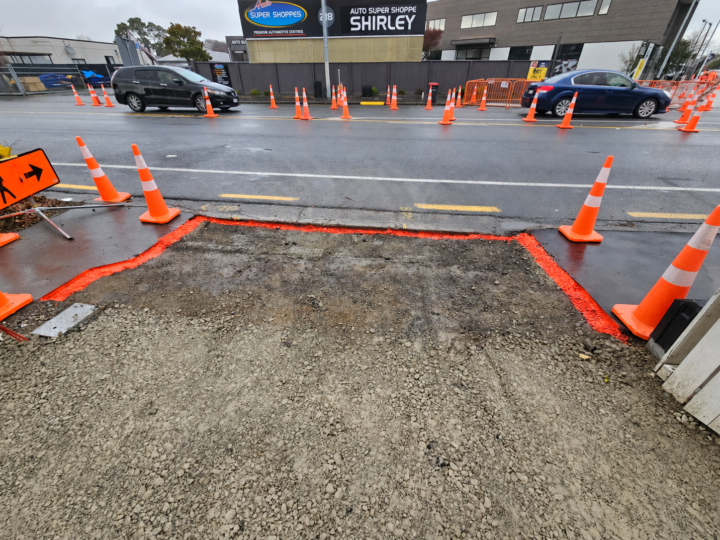 Traffic cones and a prepared excavation beside a New Zealand urban road